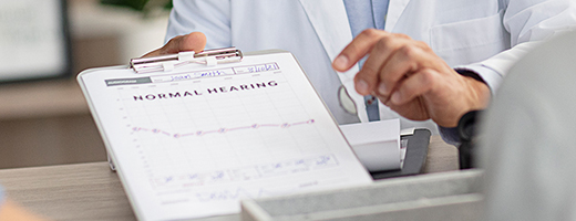 Image of hearing care professional showing an audiogram to a patient